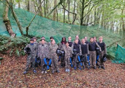Group of kids in camouflage gear ready for splatball in the forest.
